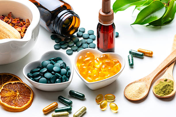 Nutritional supplements on white background. Spirulina and Omega-3 pills. Herbal therapy and essential oils. Natural vitamins or healthy eating and dieting. Healthcare or alternative medicine